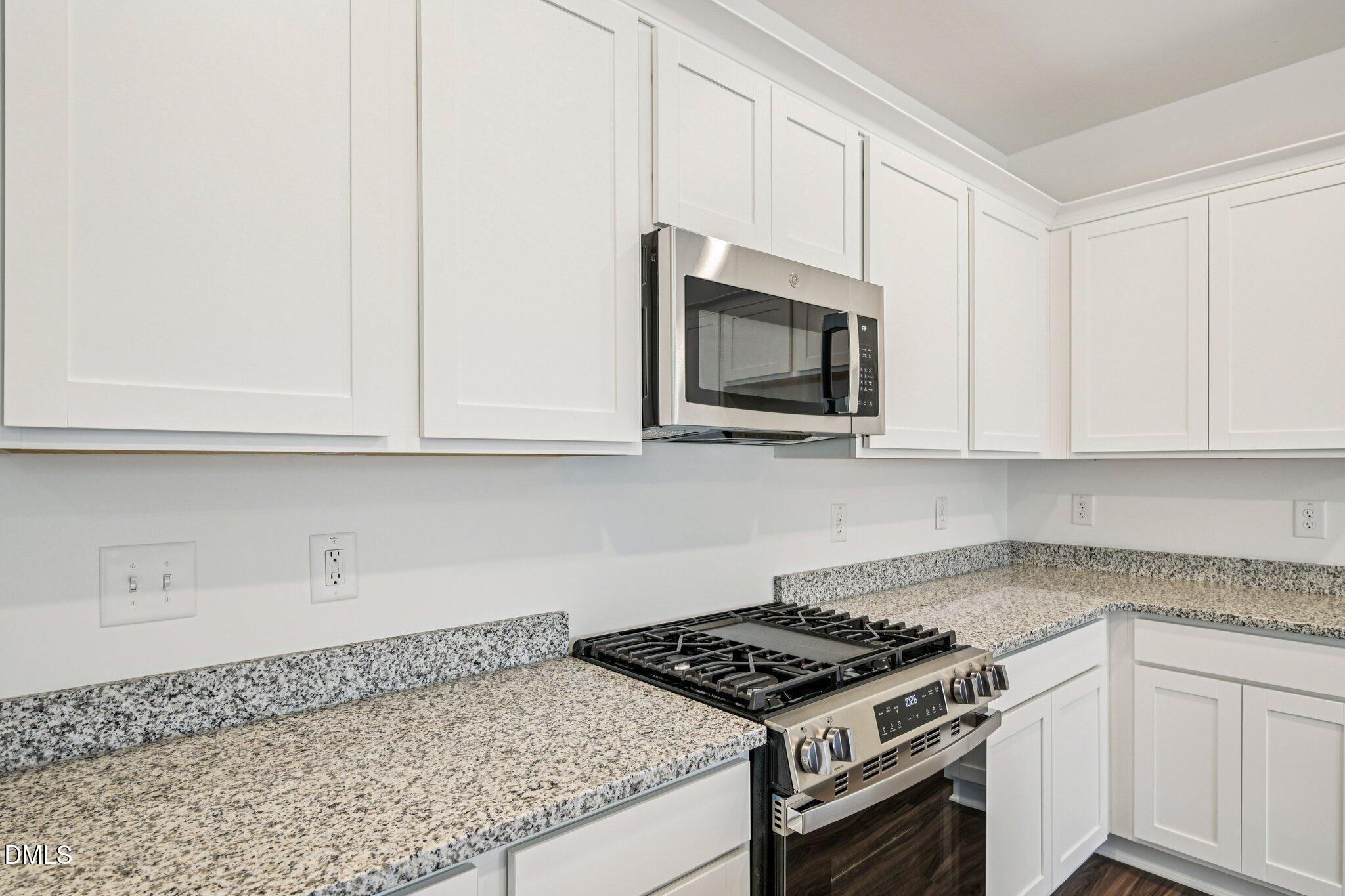 1522 Mirth Court Rolesville, NC 27571 - Photo 11 of 34 a kitchen with granite countertop white cabinets and stainless steel appliances