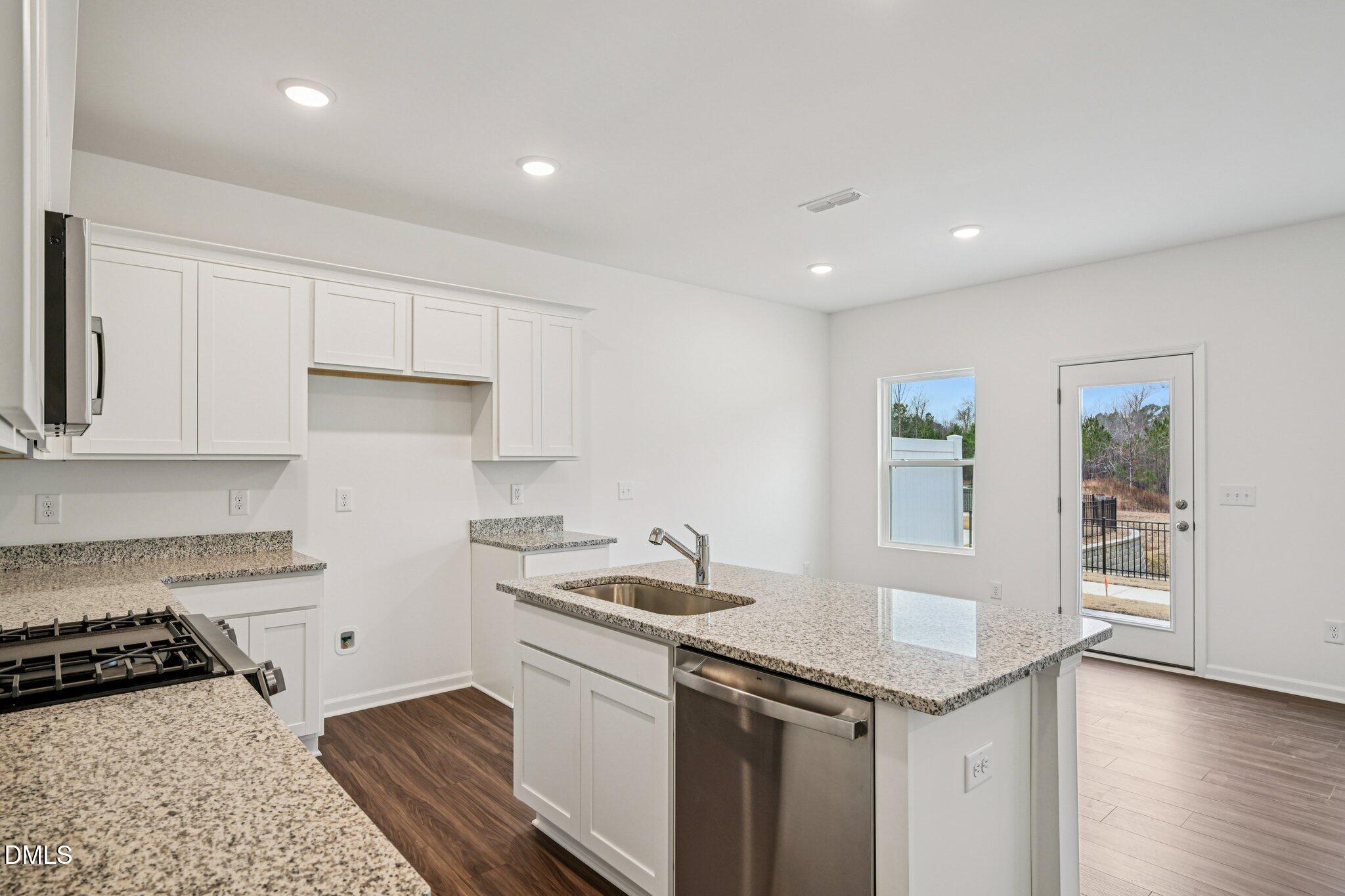 1522 Mirth Court Rolesville, NC 27571 - Photo 12 of 34 a kitchen with granite countertop a sink and a stove top oven