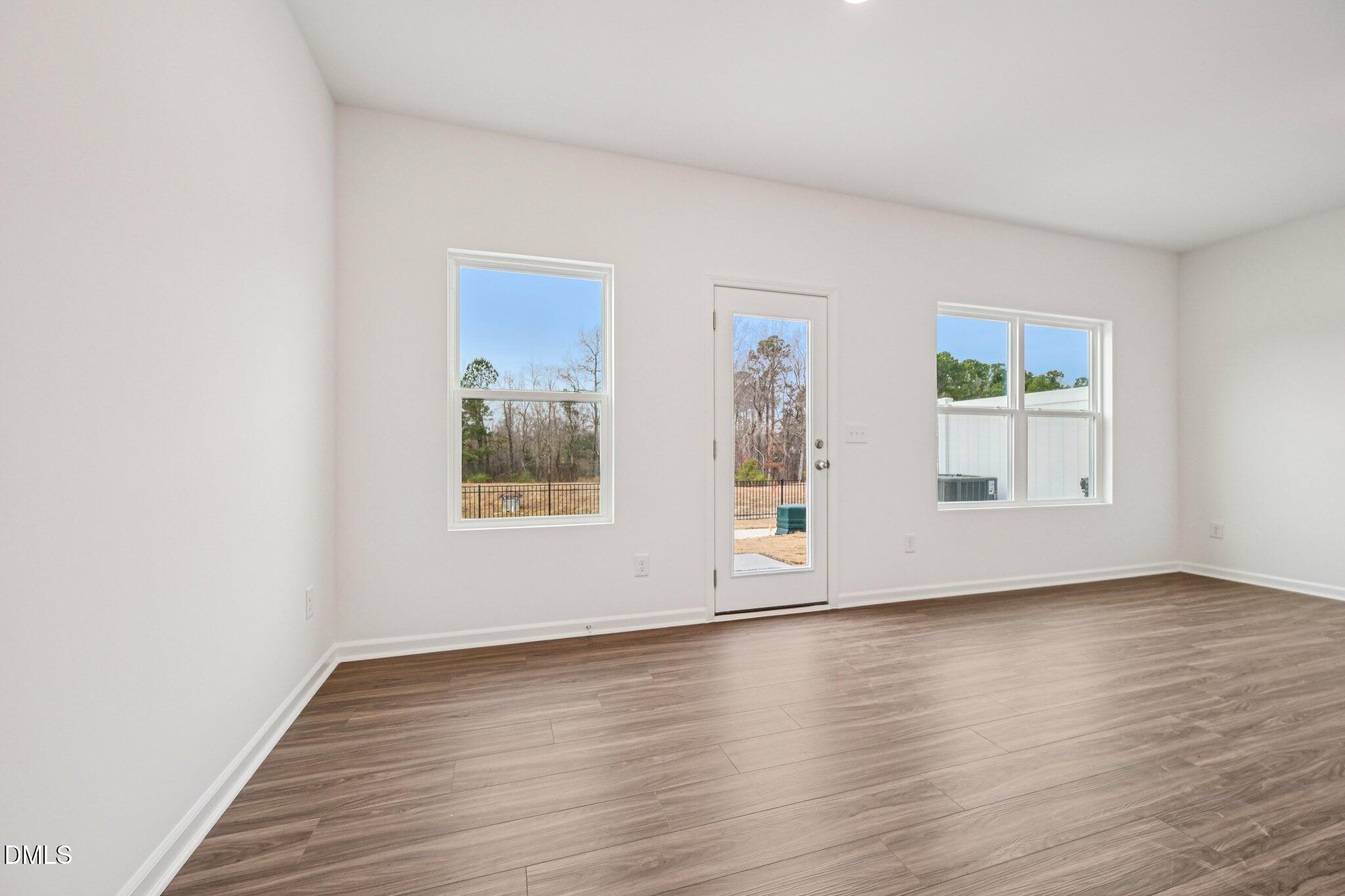 1522 Mirth Court Rolesville, NC 27571 - Photo 4 of 34 a view of an empty room with wooden floor and a window