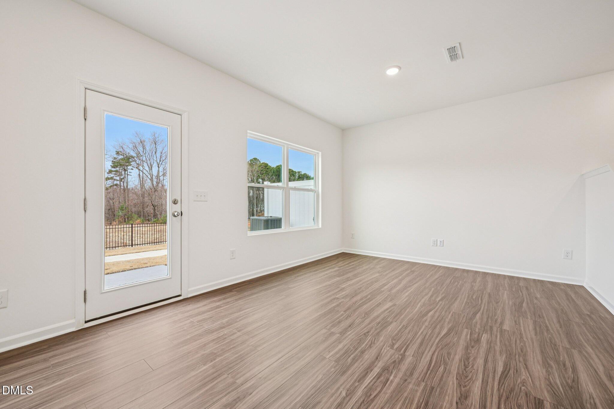 1522 Mirth Court Rolesville, NC 27571 - Photo 6 of 34 an empty room with wooden floor and a window