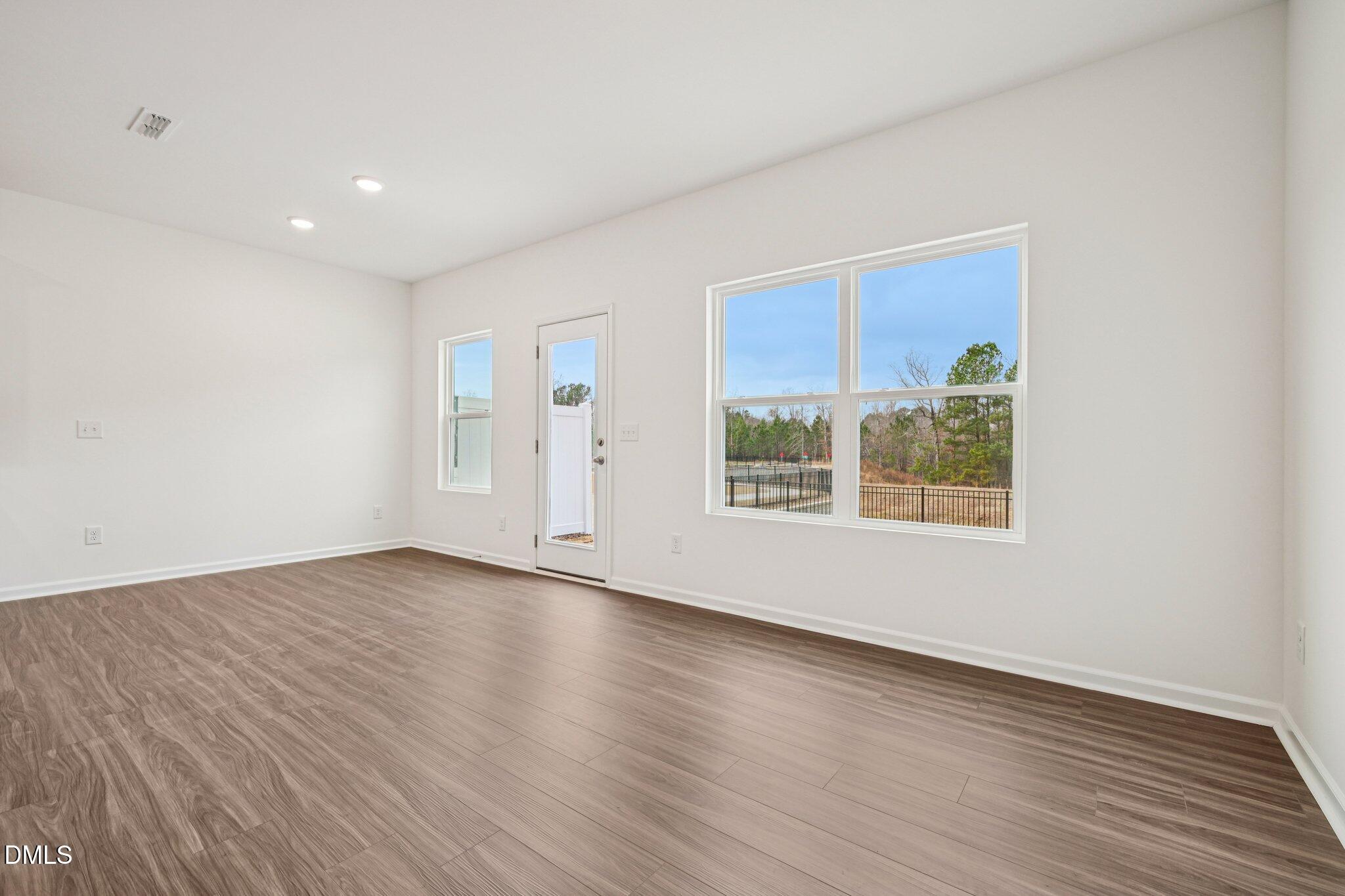 1522 Mirth Court Rolesville, NC 27571 - Photo 7 of 34 a view of an empty room with wooden floor and a window