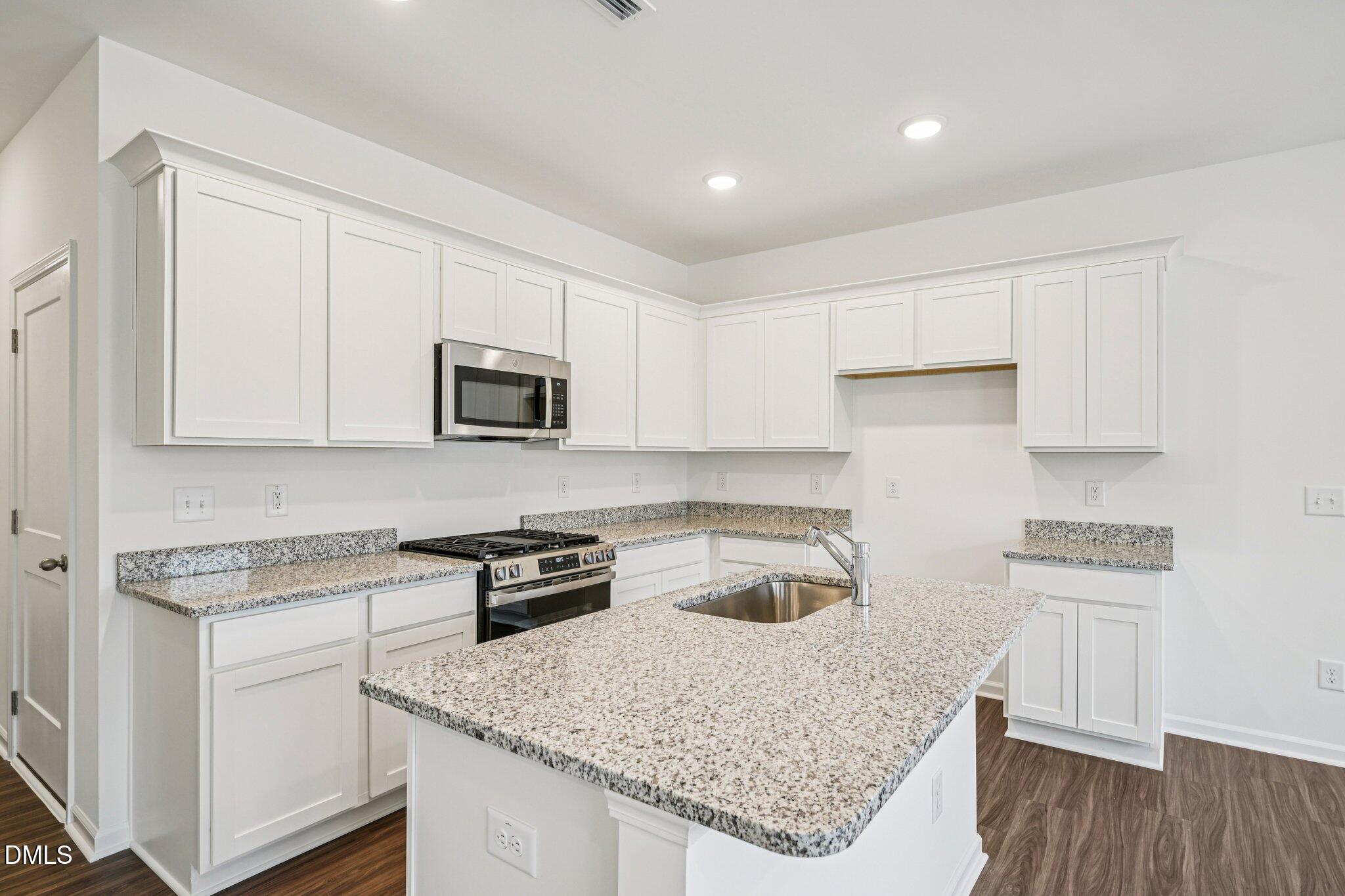 1522 Mirth Court Rolesville, NC 27571 - Photo 8 of 34 a kitchen with stainless steel appliances granite countertop a sink stove and refrigerator