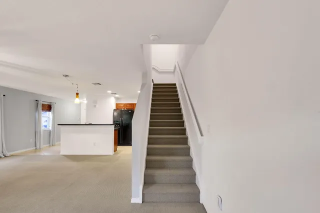 a view of a kitchen with stairs and a white wall