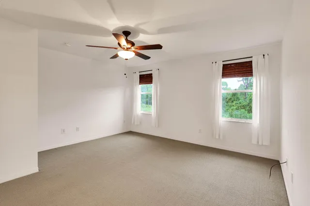 an empty room with a window and a fan