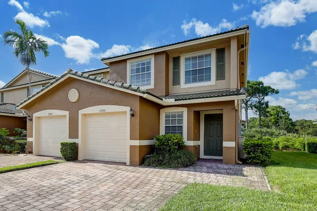 a view of a house with a yard and potted plants