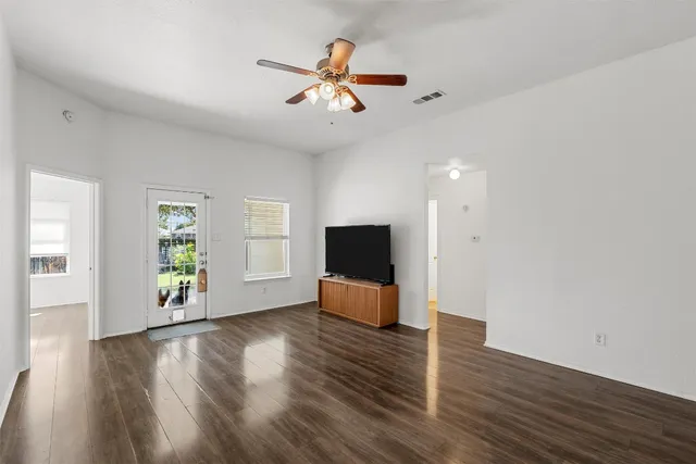 a living room with hardwood floor and a ceiling fan