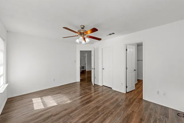 an empty room with wooden floor and a window