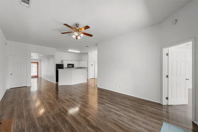 a view of a kitchen with wooden floor and a ceiling fan
