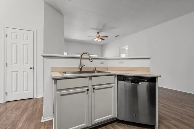 a kitchen with a sink cabinets and wooden floor