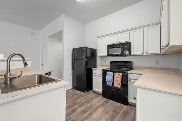 a kitchen with a refrigerator sink and wooden cabinets