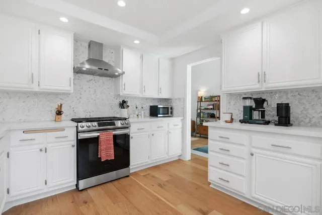 a kitchen with white cabinets and white appliances