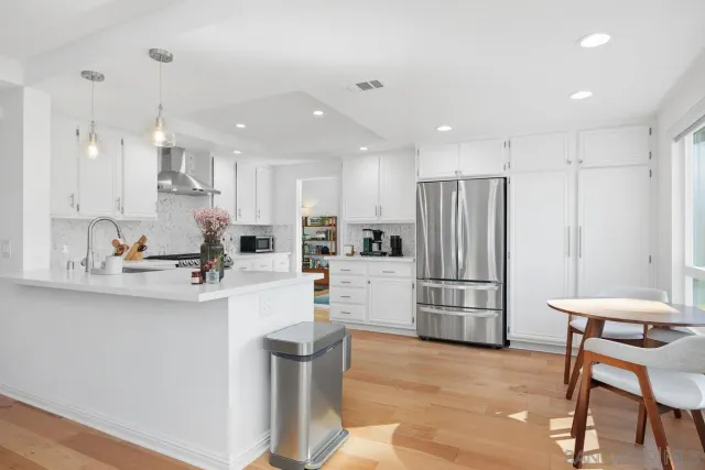 a kitchen with refrigerator and chairs