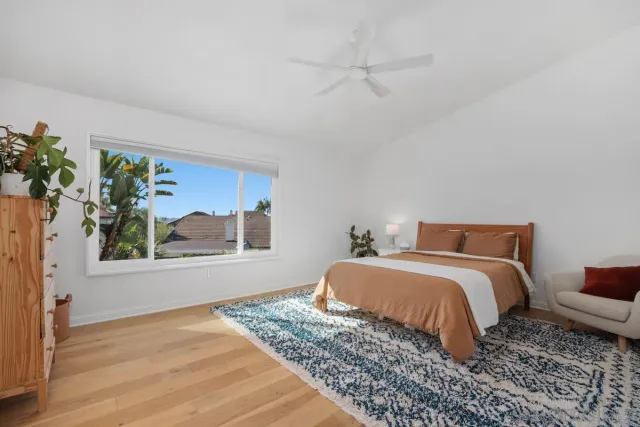 a bedroom with a bed and a painting on the wall
