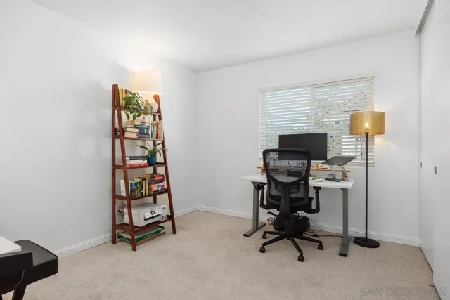 a view of a workspace with furniture and a window