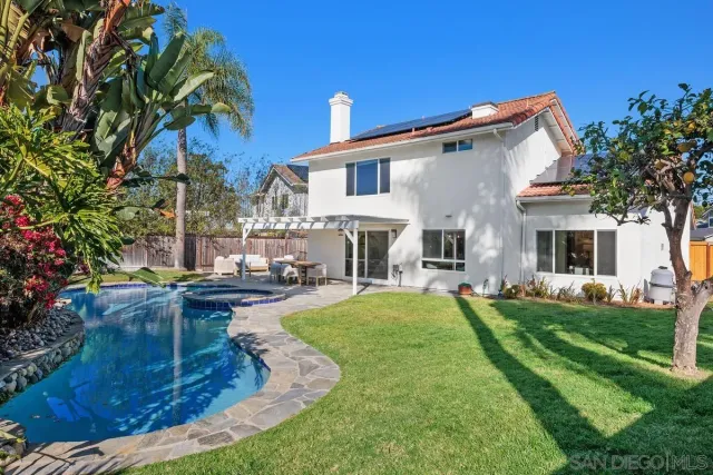 a view of a house with backyard and sitting area