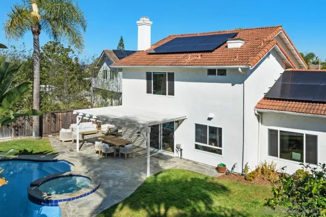 a backyard of a house with fireplace table and chairs