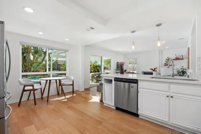 a kitchen with a table chairs sink and cabinets