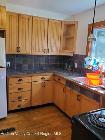 a kitchen with granite countertop a sink a stove and cabinets