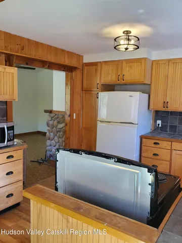 a kitchen with stainless steel appliances wooden floor and a refrigerator
