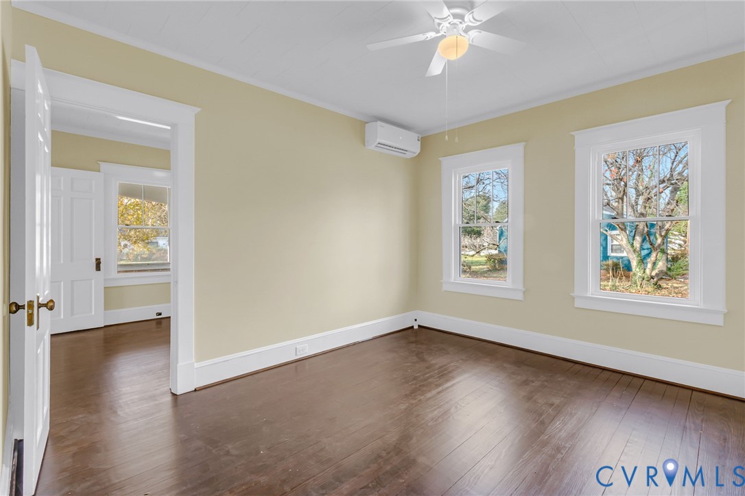 109 Courthouse Road Heathsville, VA 22473 - Photo 14 of 50 an empty room with wooden floor chandelier fan and windows