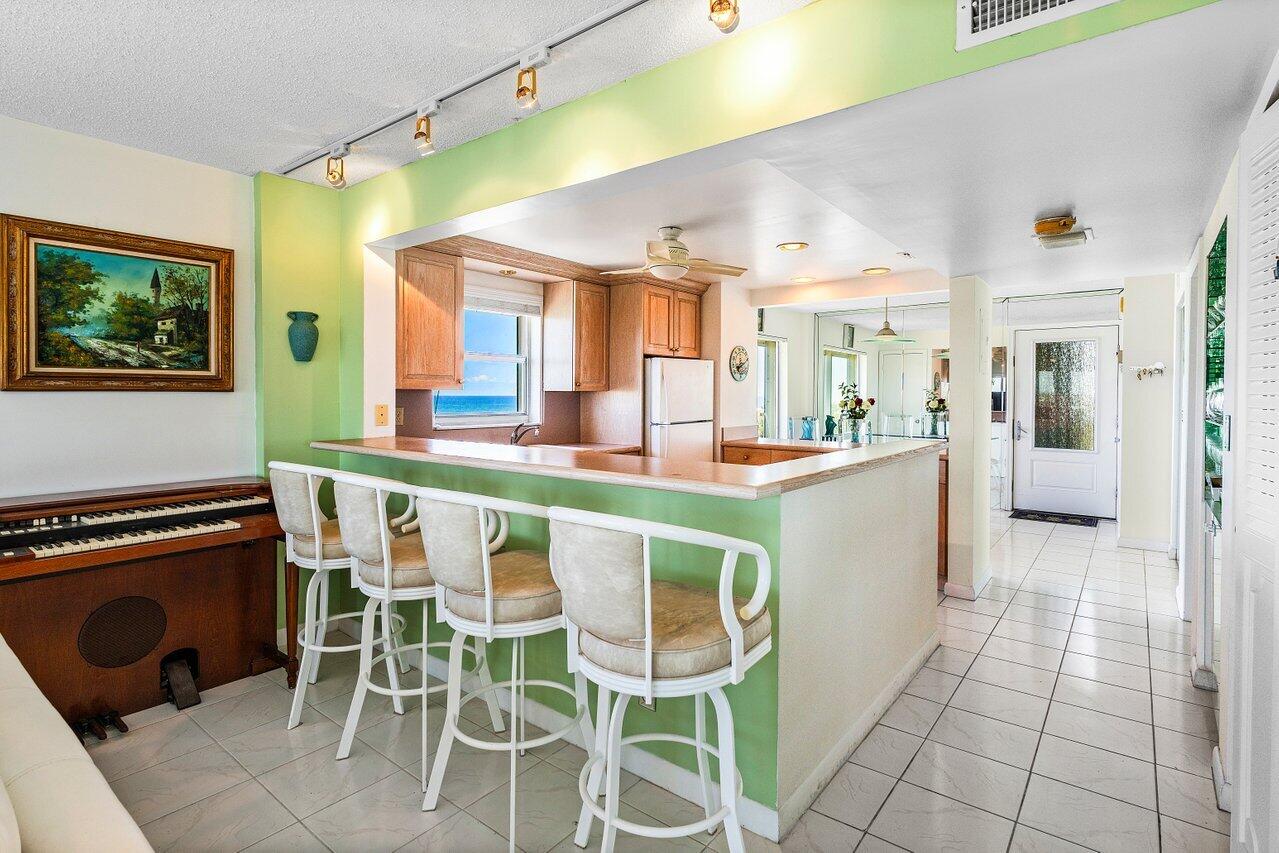 2611 North Riverside Drive, Unit 908 Pompano Beach, FL 33062 - Photo 13 of 43 a dining hall with stainless steel appliances kitchen island granite countertop a table chairs and a view of living room