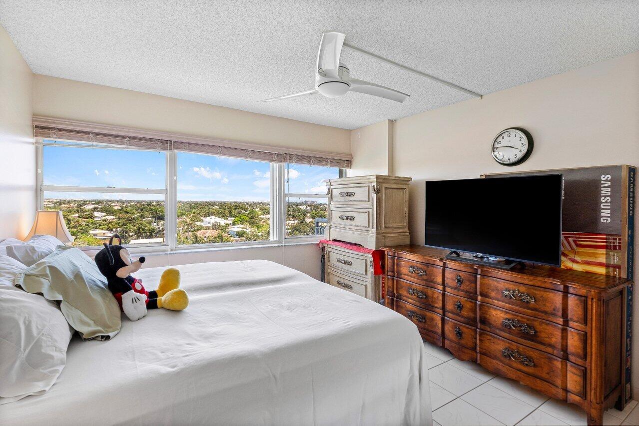 2611 North Riverside Drive, Unit 908 Pompano Beach, FL 33062 - Photo 26 of 43 a bedroom with furniture and a flat screen tv
