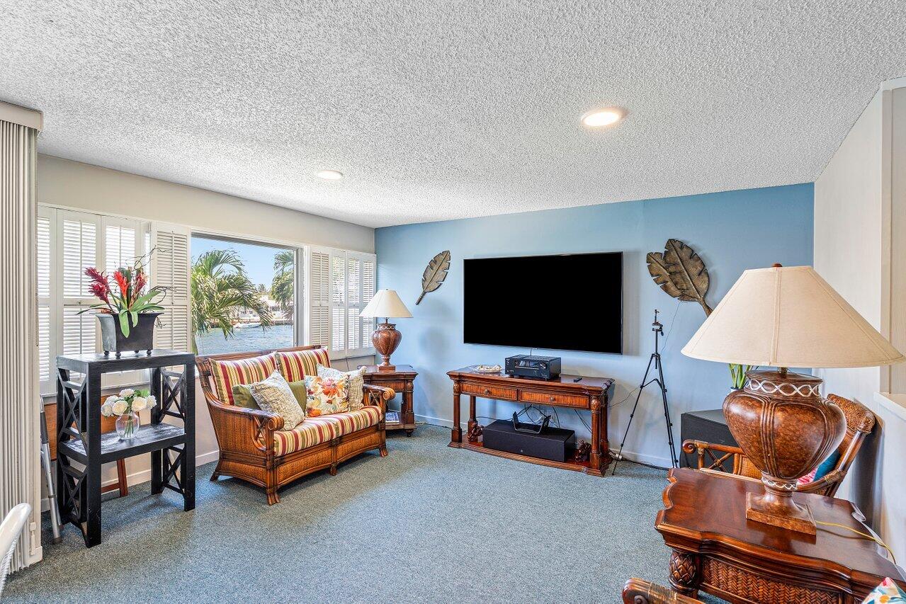 2611 North Riverside Drive, Unit 908 Pompano Beach, FL 33062 - Photo 38 of 43 a living room with furniture and a flat screen tv