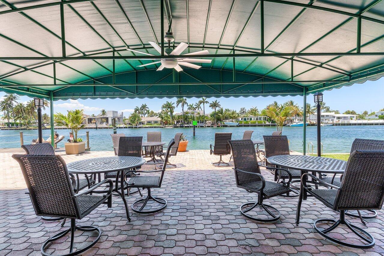 2611 North Riverside Drive, Unit 908 Pompano Beach, FL 33062 - Photo 41 of 43 a view of patio with a table and chairs under an umbrella