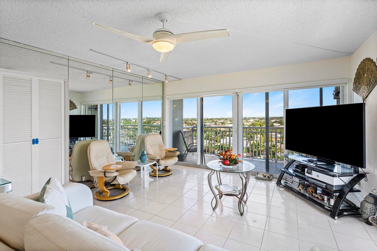 2611 North Riverside Drive, Unit 908 Pompano Beach, FL 33062 - Photo 10 of 43 a living room with furniture a flat screen tv and a large window
