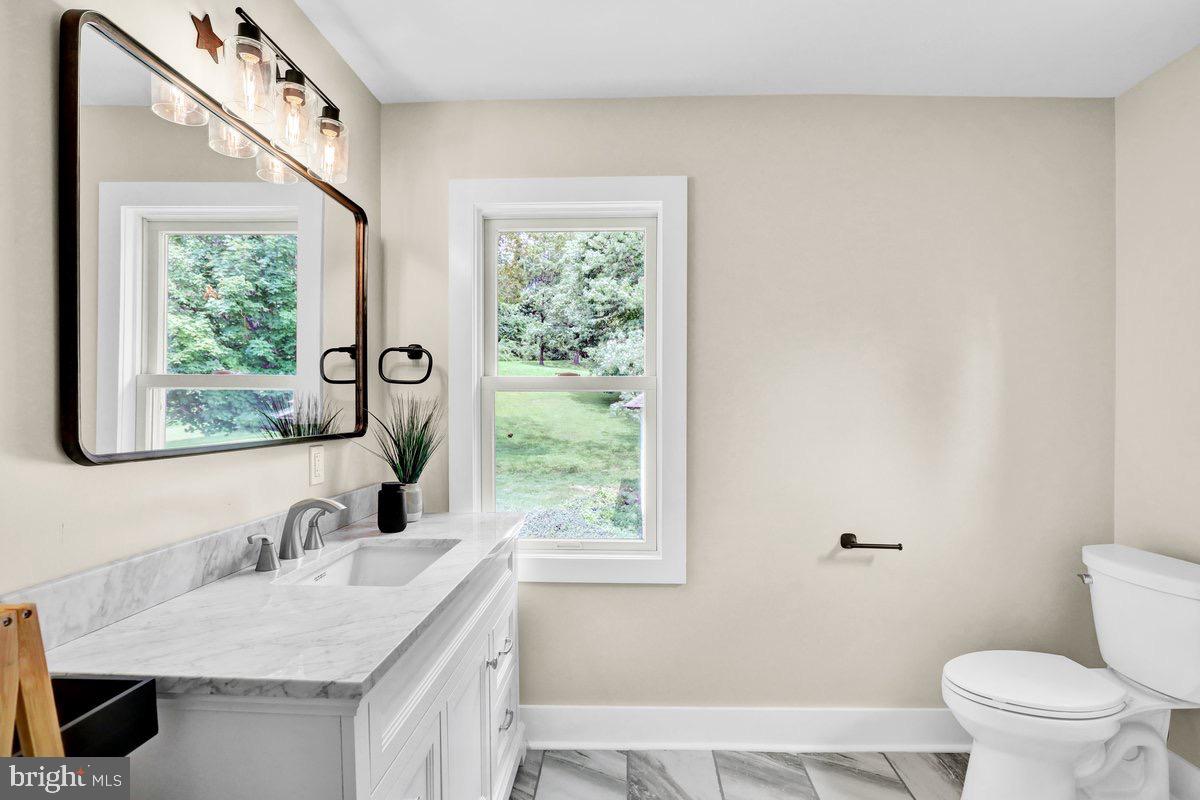 1069 Rawlinsville Road Willow Street, PA 17584 - Photo 21 of 47 a bathroom with a granite countertop sink a toilet and a window