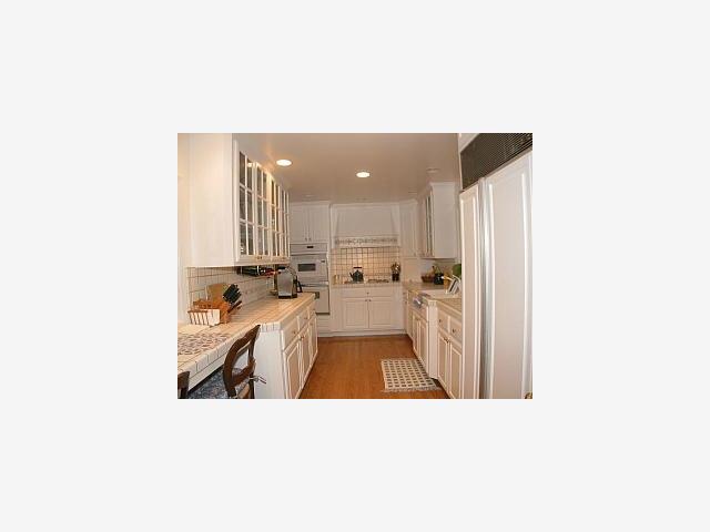 3039 Sherman Road Pebble Beach, CA 93953 - Photo 3 of 5 a open kitchen with stainless steel appliances kitchen island sink refrigerator and stove with wooden floor