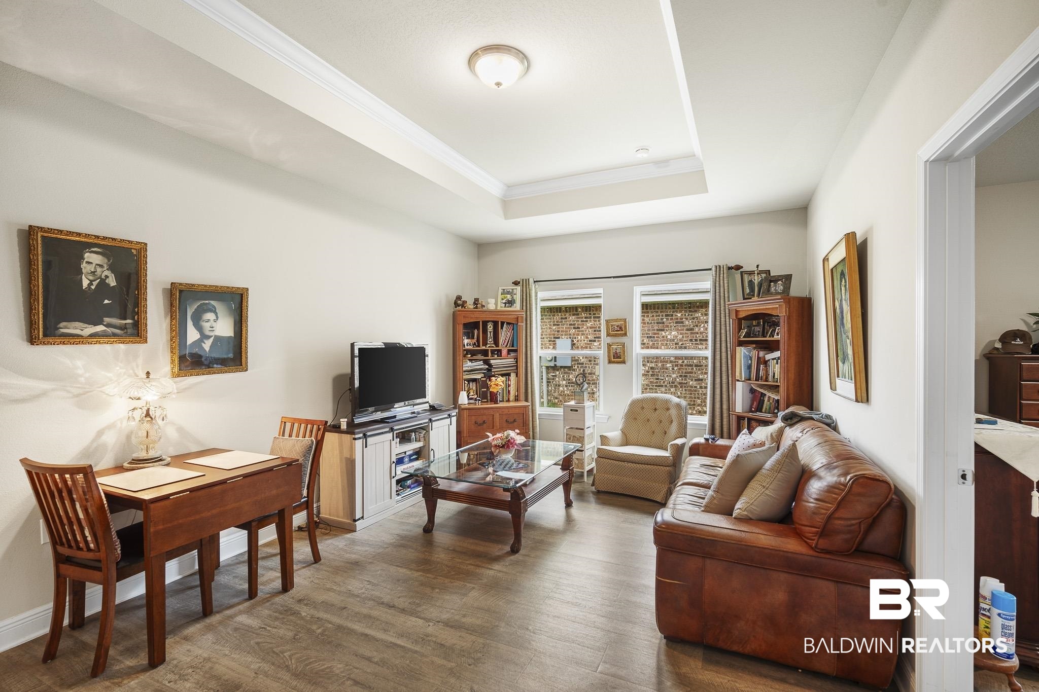 24765 Spectacular Bid Loop Daphne, AL 36526 - Photo 10 of 45 Living room featuring crown molding, a tray ceiling, and dark wood-type flooring