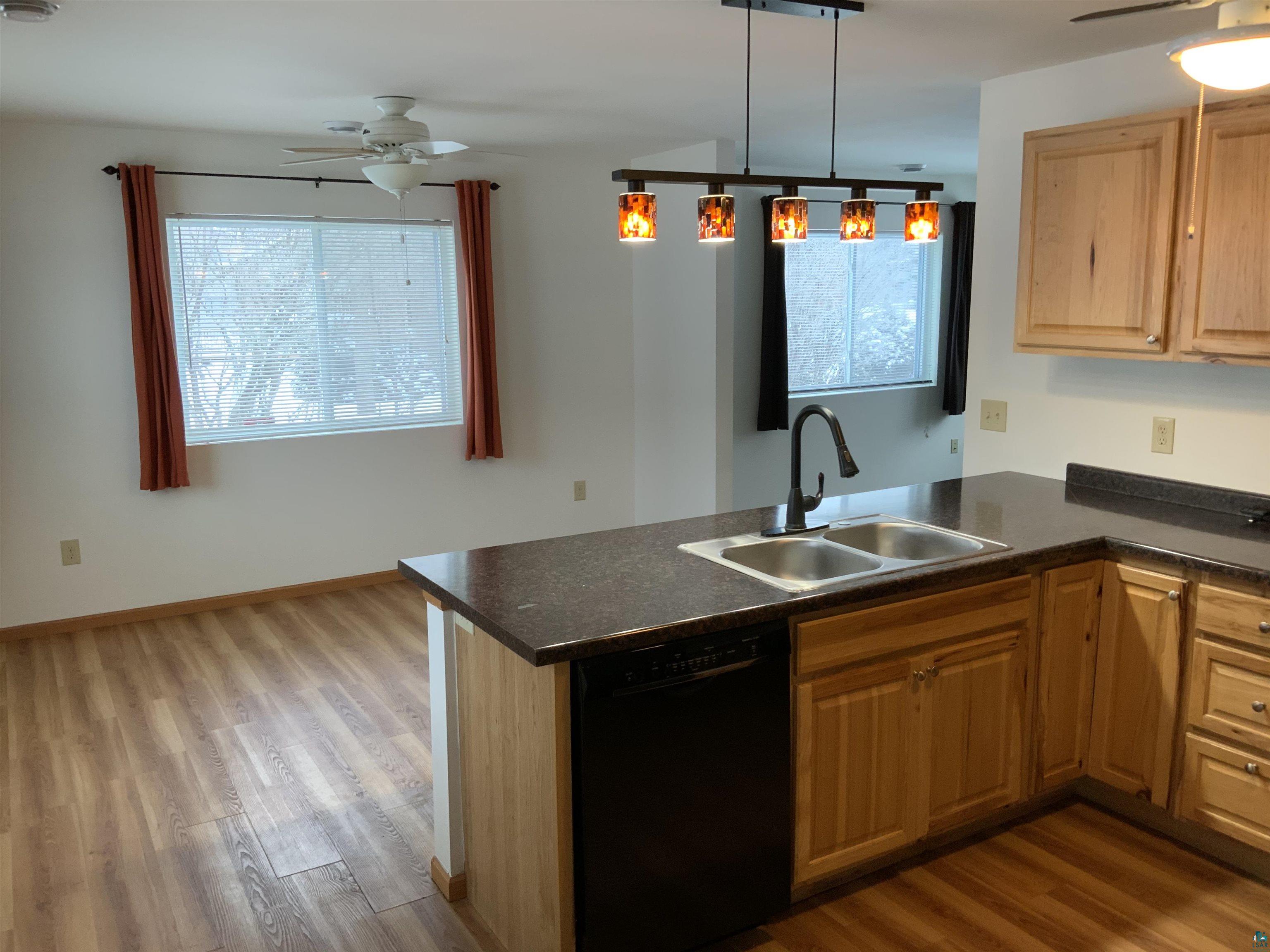 904 Spring Lake Road Cloquet, MN 55720 - Photo 4 of 14 Kitchen with hardwood / wood-style flooring, sink, black dishwasher, and kitchen peninsula