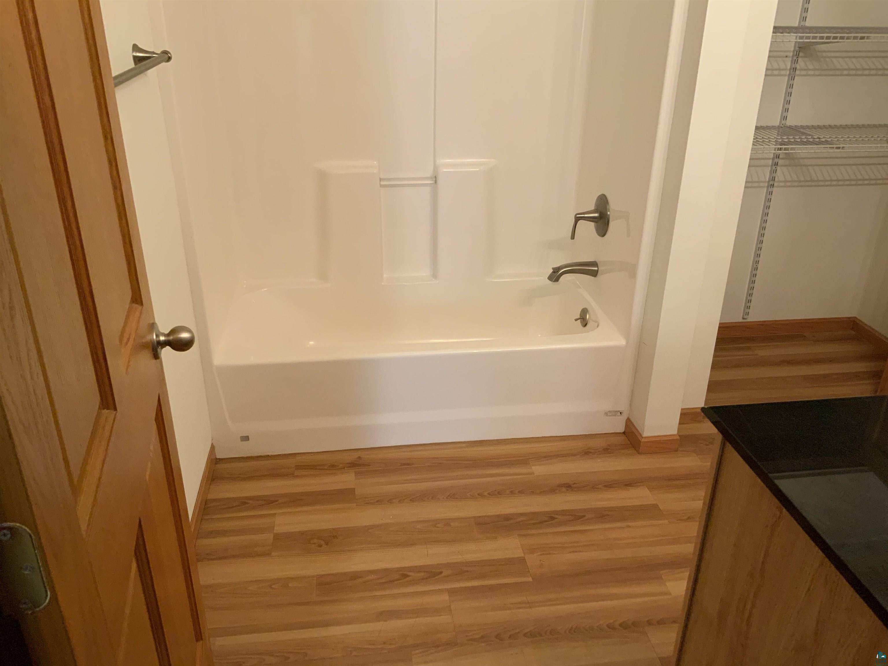 904 Spring Lake Road Cloquet, MN 55720 - Photo 8 of 14 Bathroom with hardwood / wood-style floors, vanity, and tub / shower combination