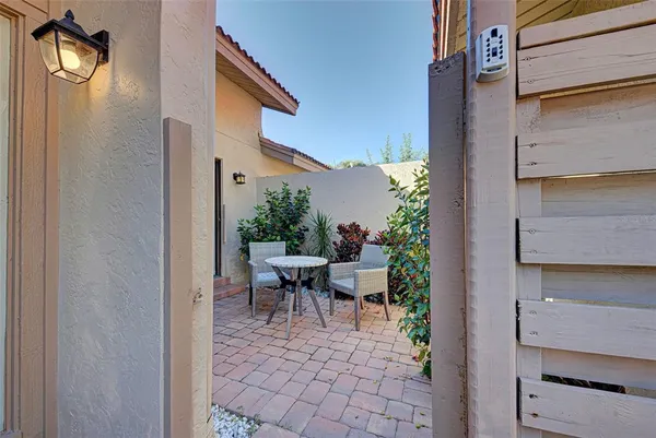 a view of a patio with table and chairs and potted plants