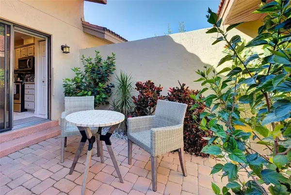 a roof deck with table and chairs and potted plants