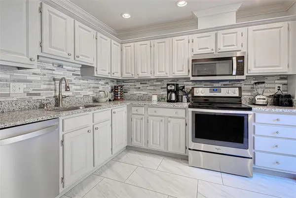 a kitchen with cabinets stainless steel appliances and sink