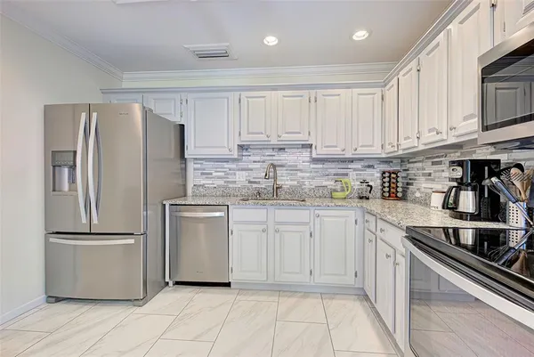 a kitchen with stainless steel appliances granite countertop a refrigerator sink and cabinets