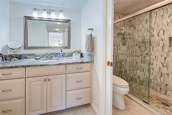 a bathroom with a granite countertop sink toilet and shower