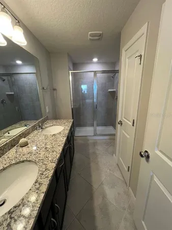 a en suite bathroom with a granite countertop sink and a mirror