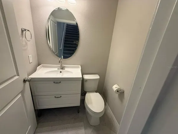 a bathroom with a granite countertop sink toilet mirror and bathtub
