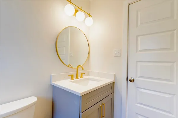 a bathroom with a sink a toilet and a mirror