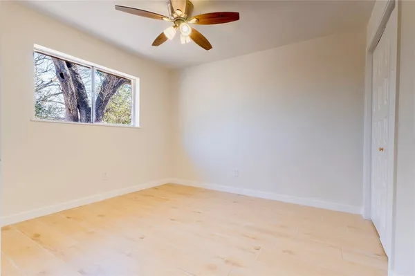 an empty room with a window and a fan