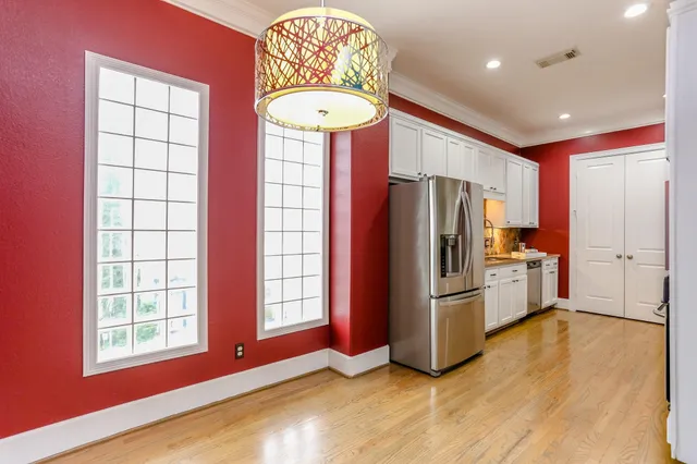 a kitchen with stainless steel appliances granite countertop a refrigerator a stove a sink and a large window