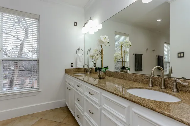 a bathroom with double vanity and a mirror