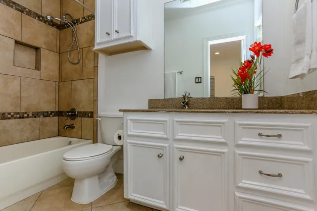 a bathroom with a granite countertop sink mirror vanity and toilet