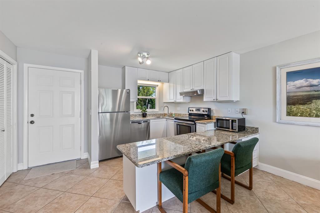5850 Gasparilla Road, Unit M4 Boca Grande, FL 33921 - Photo 11 of 36 a kitchen with kitchen island white cabinets and stainless steel appliances
