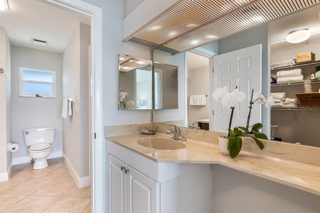 5850 Gasparilla Road, Unit M4 Boca Grande, FL 33921 - Photo 14 of 36 a bathroom with a granite countertop sink a large mirror and a toilet