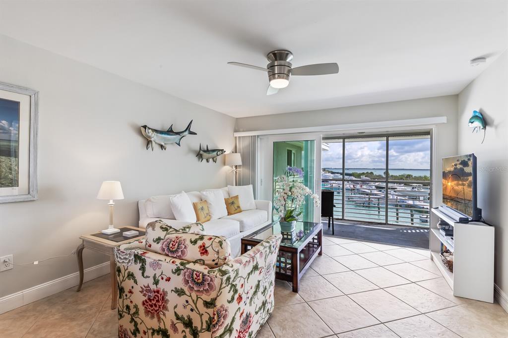 5850 Gasparilla Road, Unit M4 Boca Grande, FL 33921 - Photo 8 of 36 a living room with furniture a flat screen tv and a floor to ceiling window