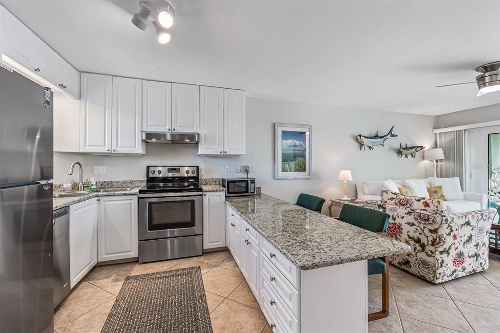 5850 Gasparilla Road, Unit M4 Boca Grande, FL 33921 - Photo 10 of 36 a large kitchen with granite countertop a stove and a sink